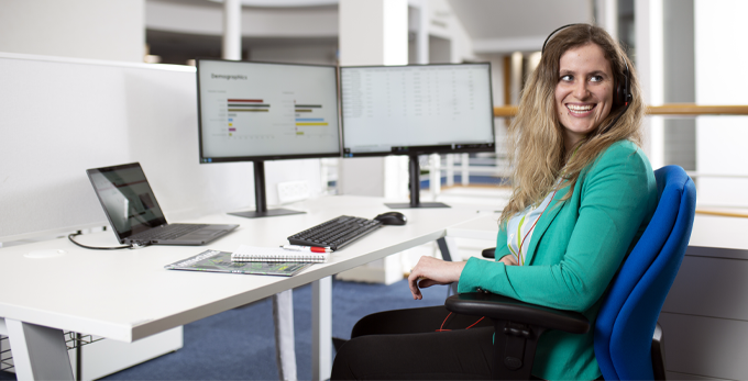 An office worker, sat at a deck at the NICEIC head office in Warwick House Dunstable 2022.