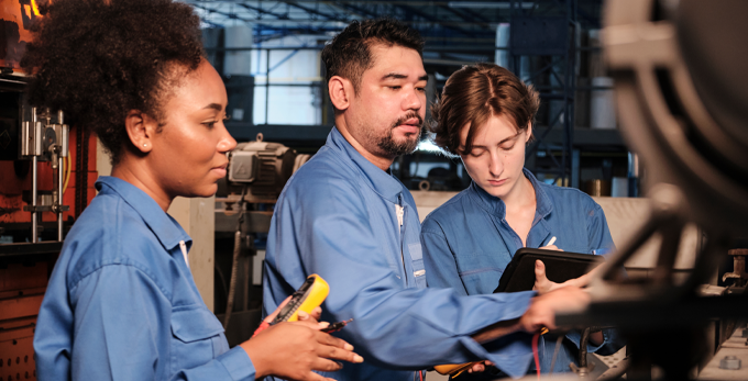 A team of contractors checking the voltage current in a industrial warehouse.