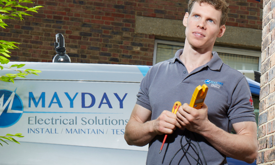 Chris May from Mayday Electrical, holding some electrical equipment 