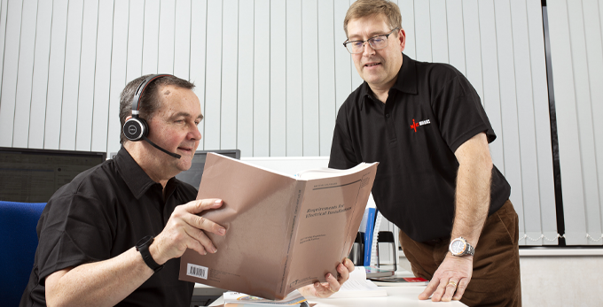 Two NICEIC management experts reviewing documents in the office headquarters at Warwick House, Dunstable.