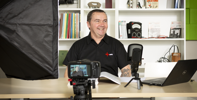 An NICEIC specialist, sat down on set, ready to begin filming an online podcast.