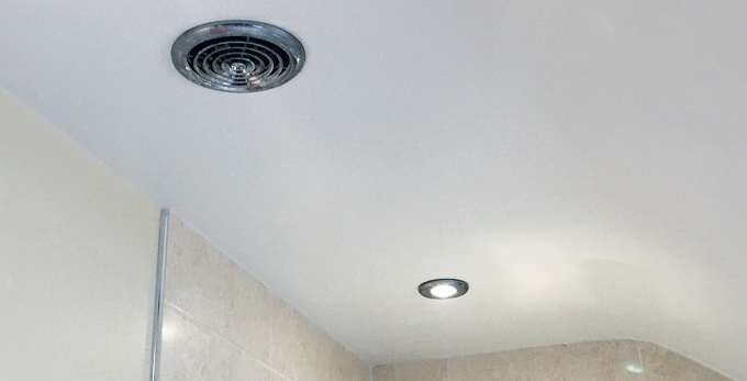 A bathroom ceiling, with LED spot lighting and chrome air ventilation cover.