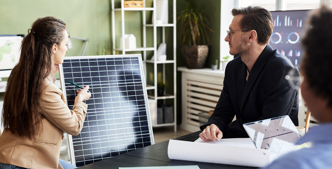 A couple asking questions about solar panel installation at a meeting in a corporate office space.