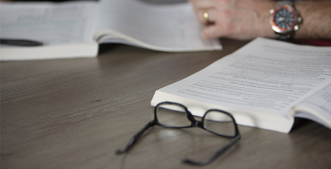 A person studying a legislation booklet on a office table.