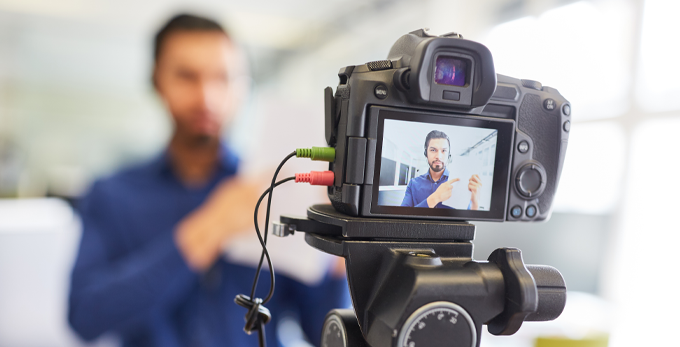 Business man in a blue shirt, recording an online podcast.